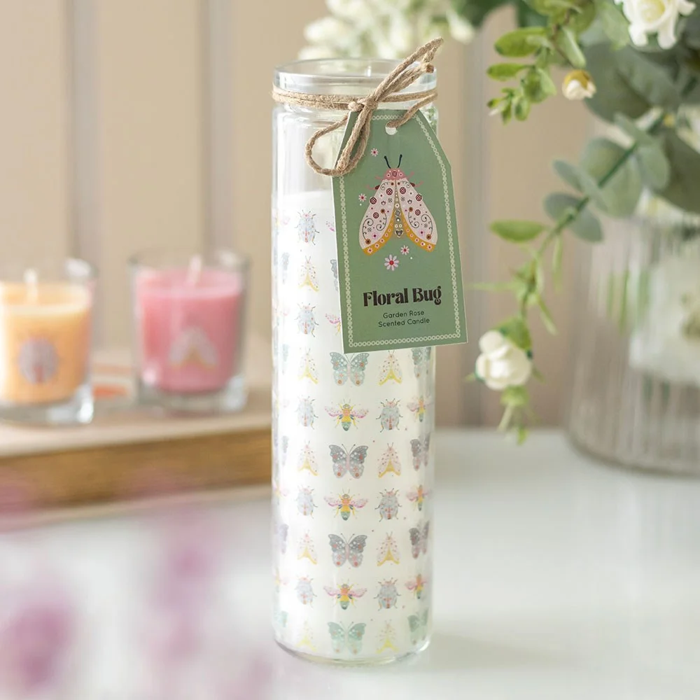 Pastel floral bug design garden rose candle in a tube shape with soft pink and green colors on paraffin wax