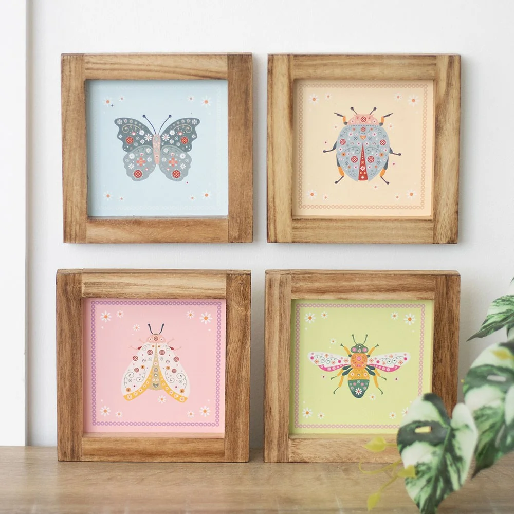 Set of 4 wooden-framed floral bug wall art prints featuring bee, butterfly, ladybird, and moth in pastel colors