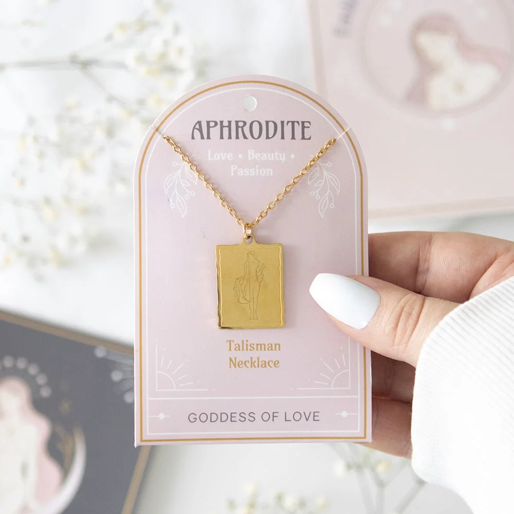 Gold-toned Aphrodite goddess necklace with detailed pendant on a matching backing card, nickel-free stainless steel chain