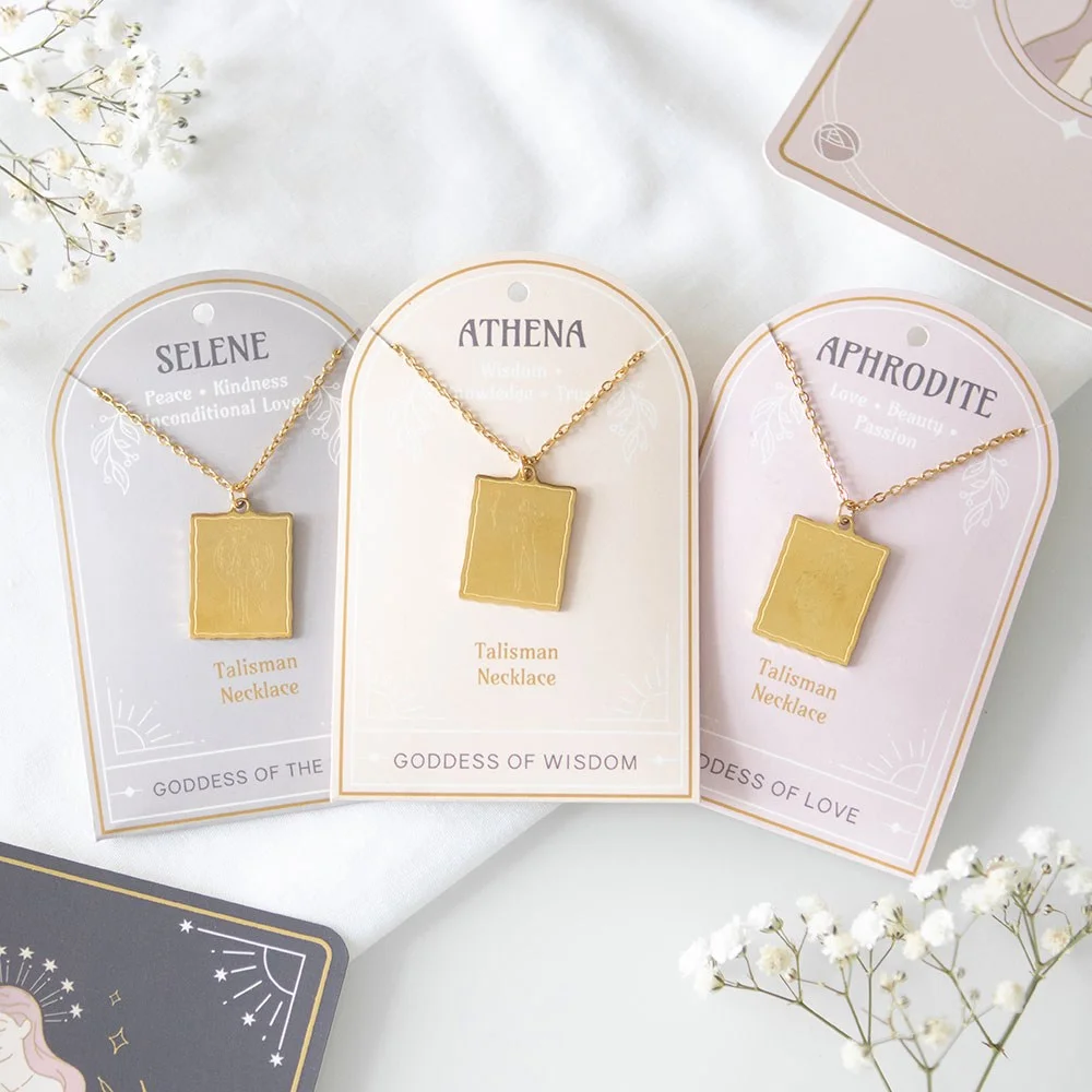 Set of 6 gold-toned goddess energy necklaces with detailed Aphrodite, Athena, and Selene pendants on backing cards