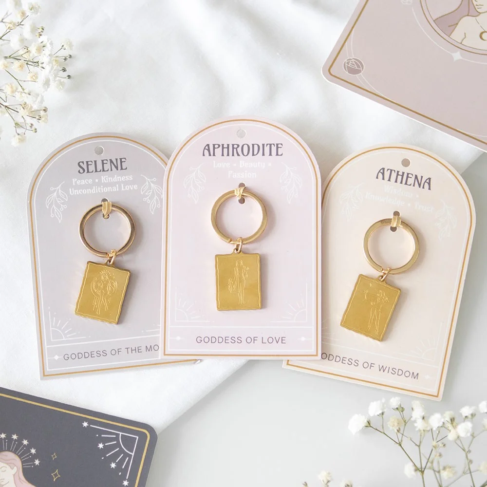 Set of 6 gold-toned goddess energy keyrings featuring Aphrodite, Athena, and Selene designs on backing cards