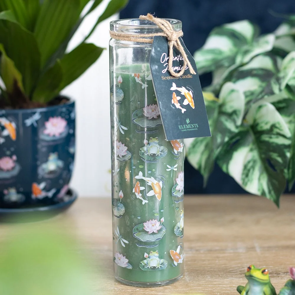 Tube candle with pond-inspired design of lily pads, frogs, dragonflies, koi fish, labelled oriental jasmine candle