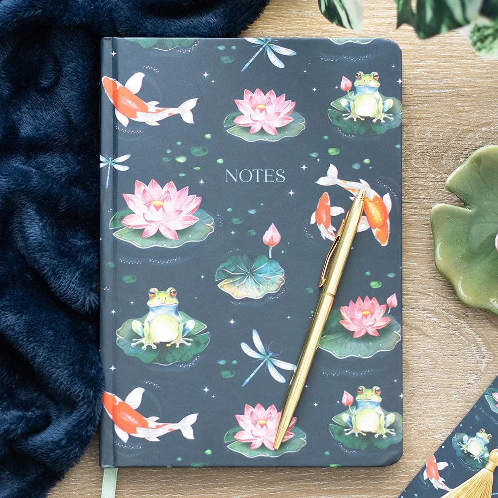 A5 notebook with pond-themed cover featuring frogs, lily pads, dragonflies, koi fish, gold foil pages, and mint ribbon marker