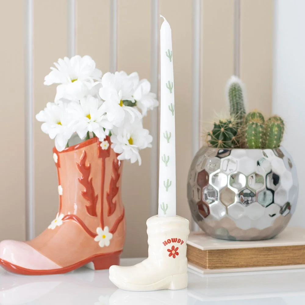 White cowboy boot candle holder with a white cactus-patterned taper candle, made of unscented paraffin wax