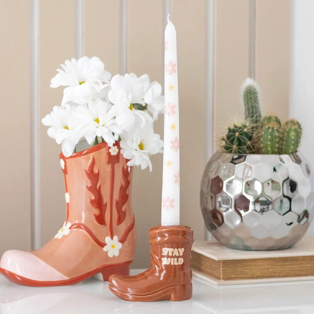 Brown cowboy boot candle holder with white floral taper candle, Western style decor accessory for cowgirls