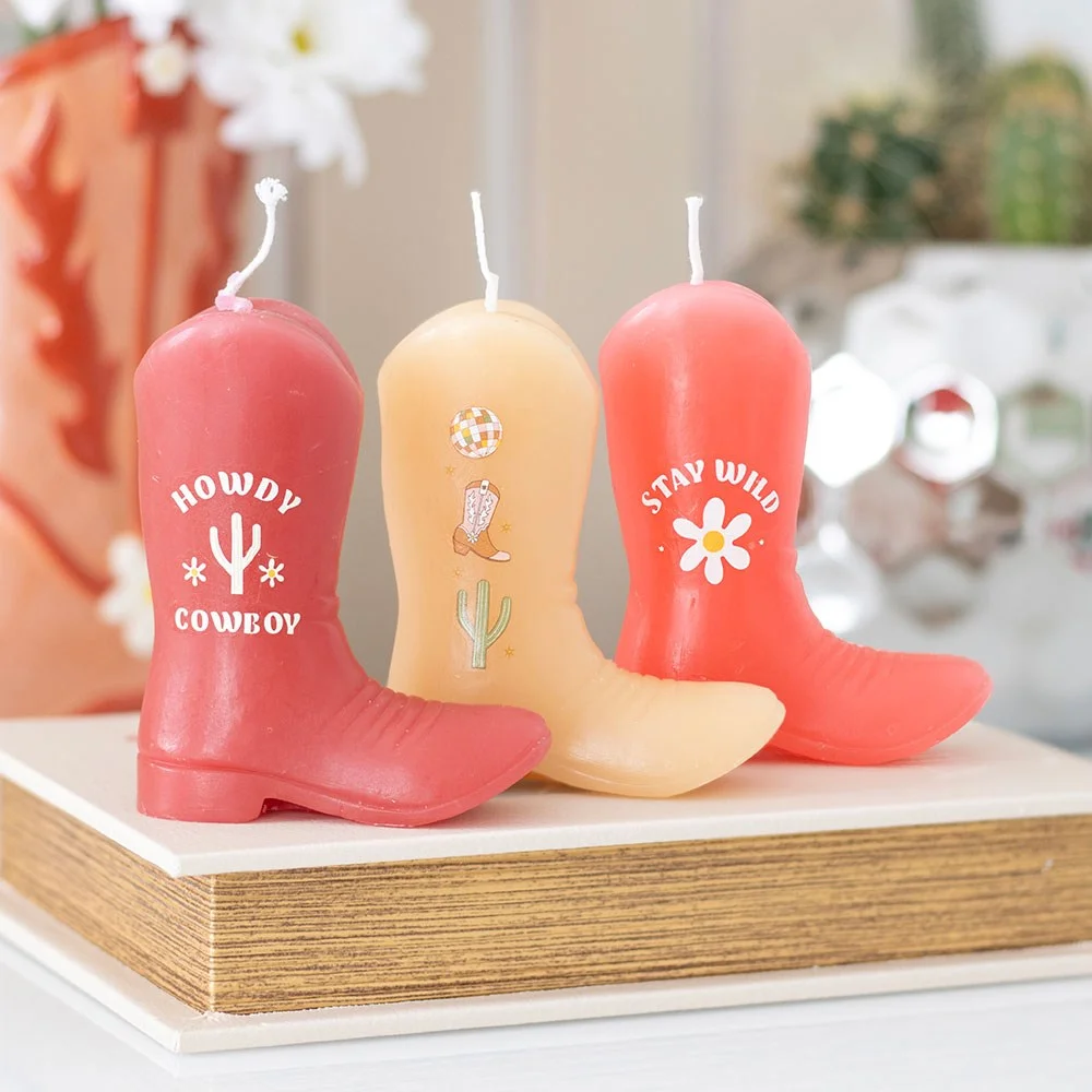 Set of three pink cowboy boot candles with Western designs, made from unscented paraffin wax, displayed together