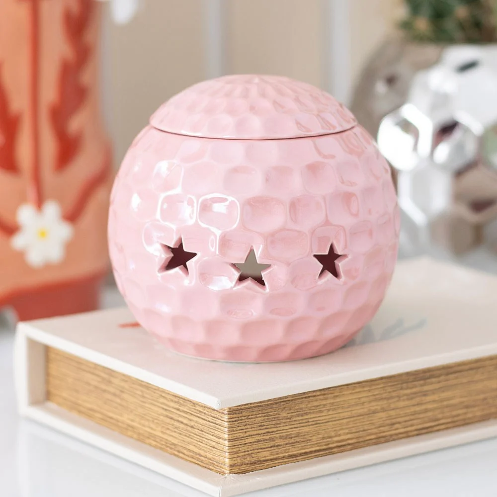 Pink disco ball oil burner with reflective facets, designed to hold fragrance oil and add a retro sparkle to your room