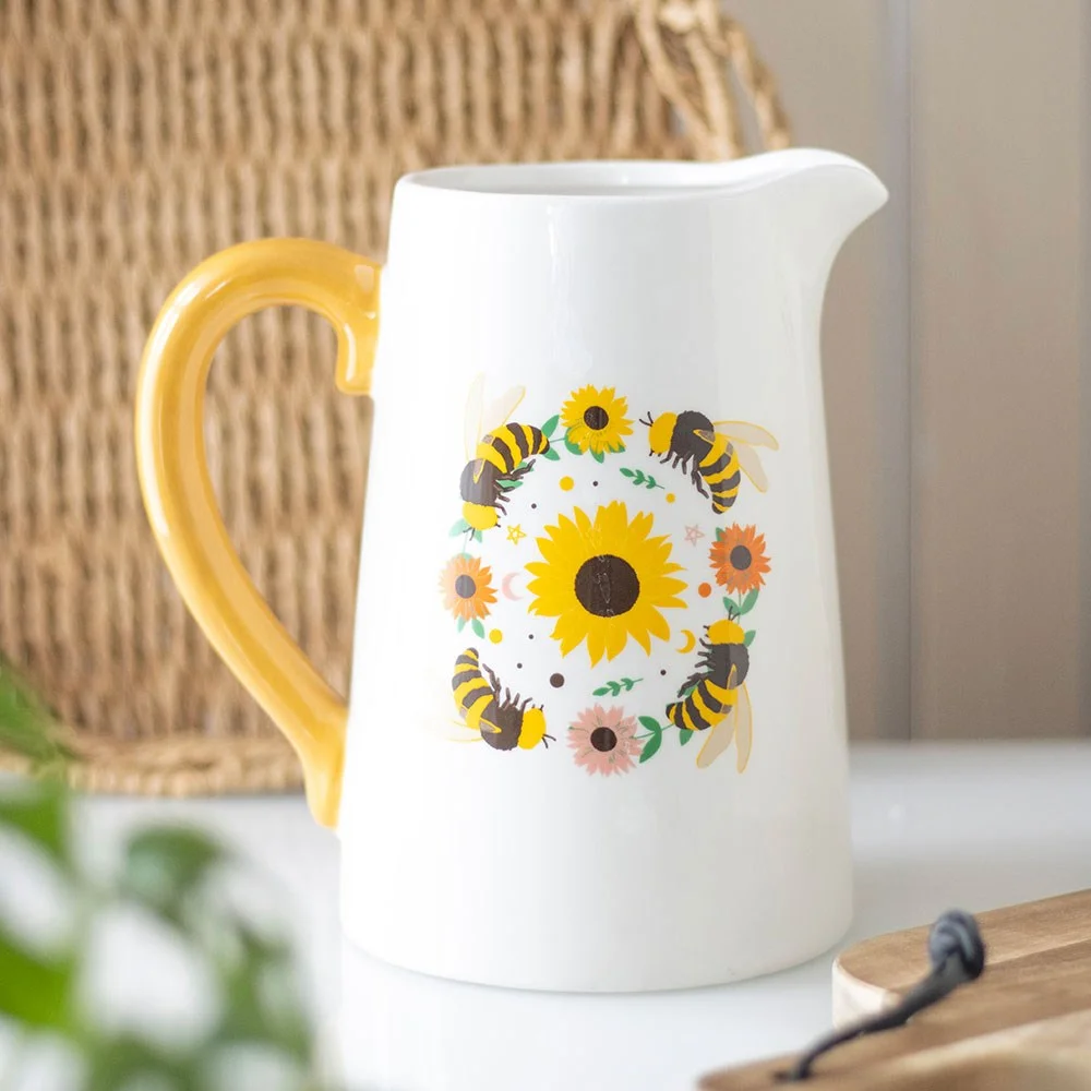 Ceramic flower jug with yellow handle featuring sunflower and bee design, ideal for displaying flowers indoors