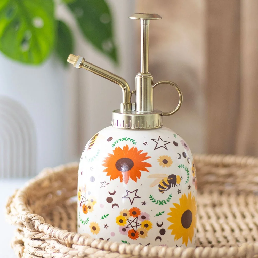 Ceramic plant mister with Summer Solstice bee and sunflower print, gold detailing, and white ceramic body