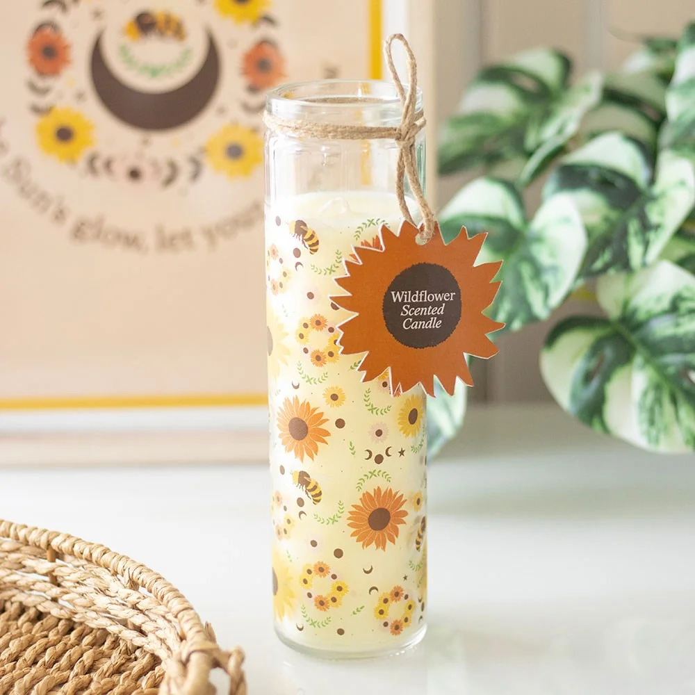 Wildflower scented candle in a tube with bees, sunflowers, pentagrams, and moon phases on the label