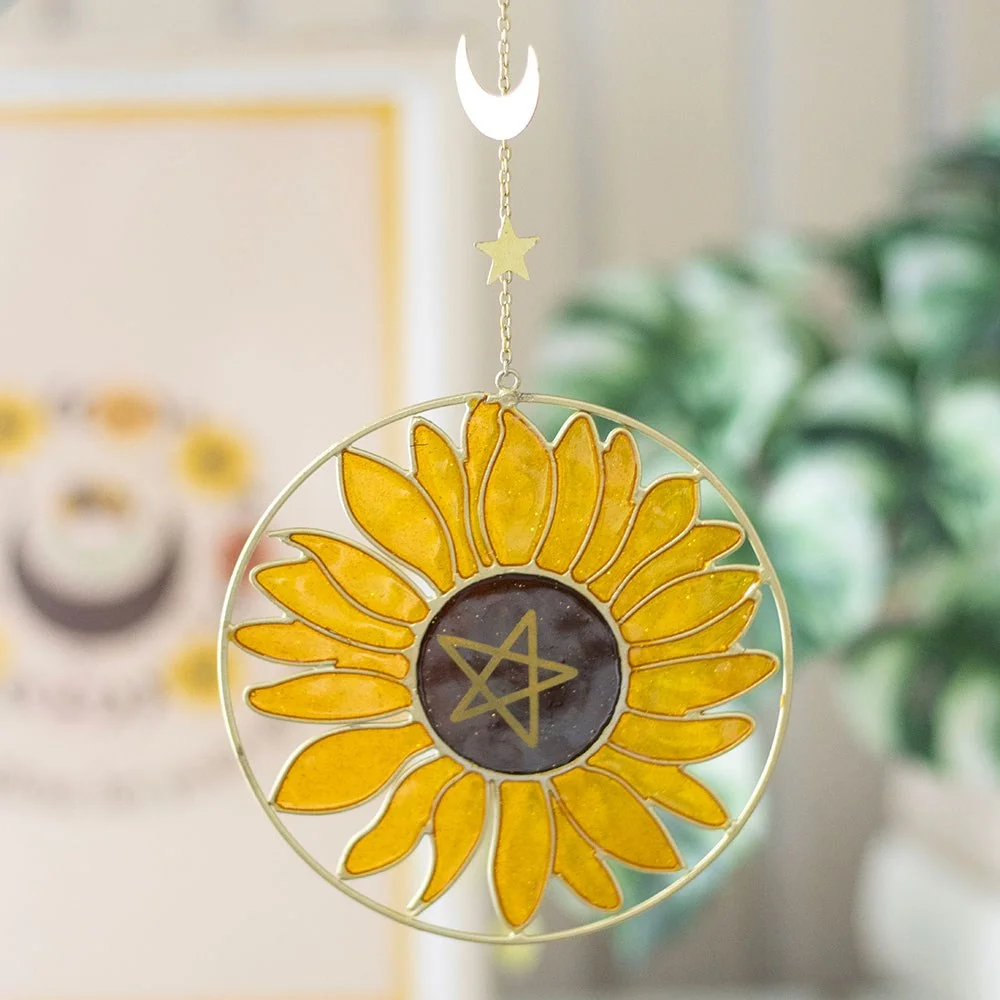 Sunflower suncatcher with metal and resin design featuring a sunflower, pentagram, star, and crescent moon hanging in window