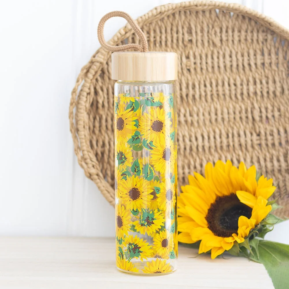 Glass water bottle with all-over sunflower print, bamboo lid, and cord loop, 600ml capacity on white background
