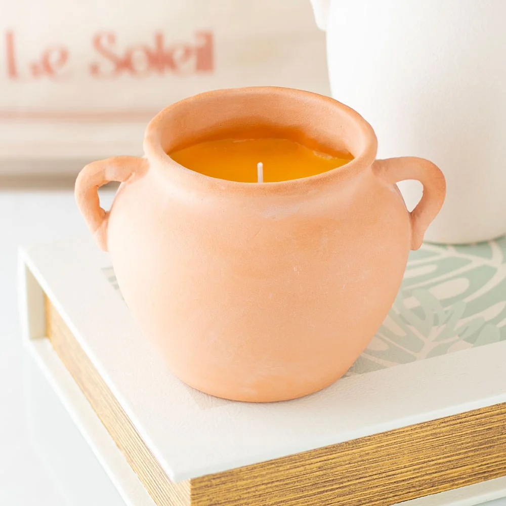 Terracotta citronella candle in rustic pot with artisan handles, lit and glowing, ideal for outdoor use and insect repellent