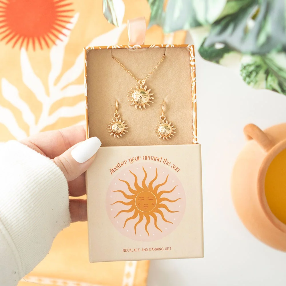Sun jewellery set with stainless steel sun-shaped necklace and matching dangly earrings in gift box with sun design