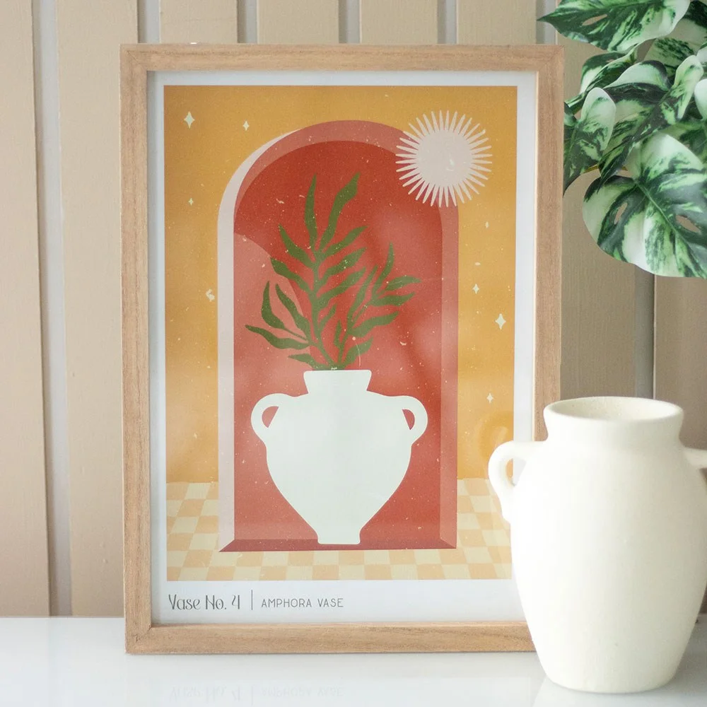 Framed wall art print featuring a modern amphora vase silhouette with warm tones and an arched window background