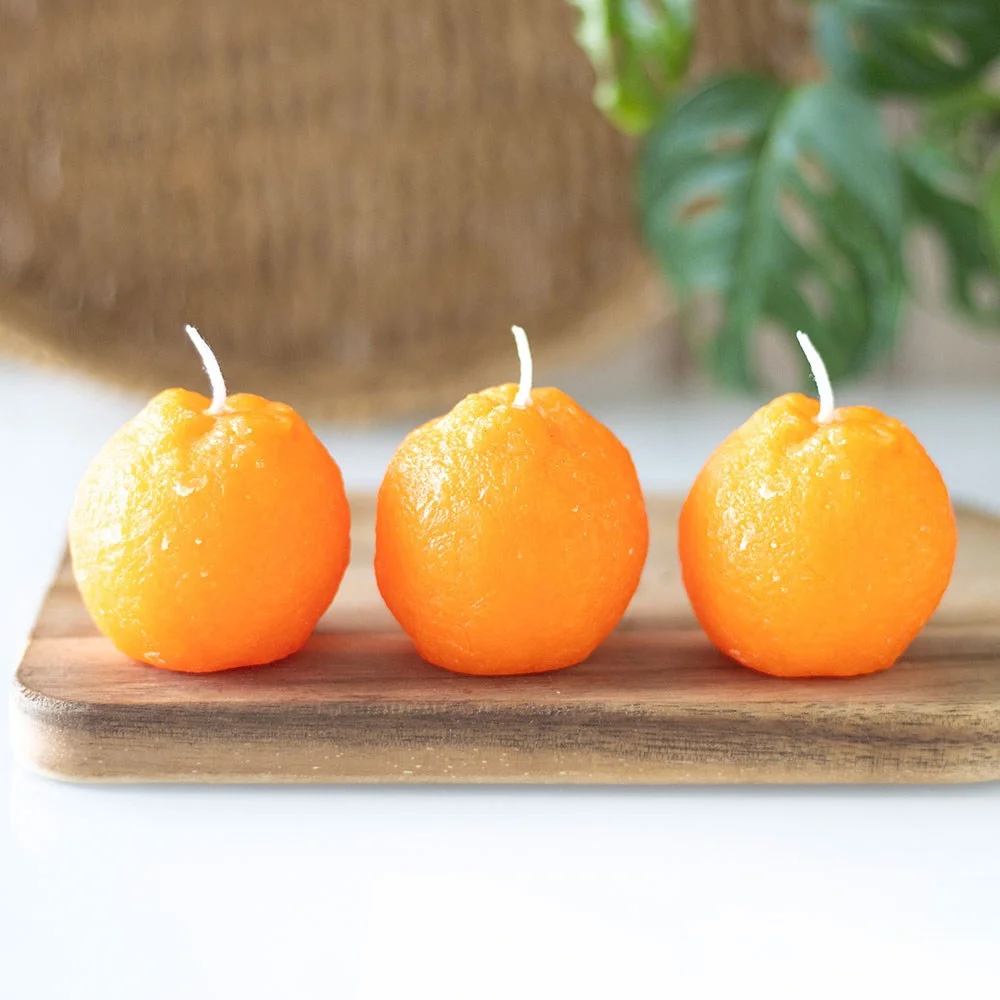 Set of 3 orange shaped candles resembling fresh oranges, unscented with a bright, vibrant orange color