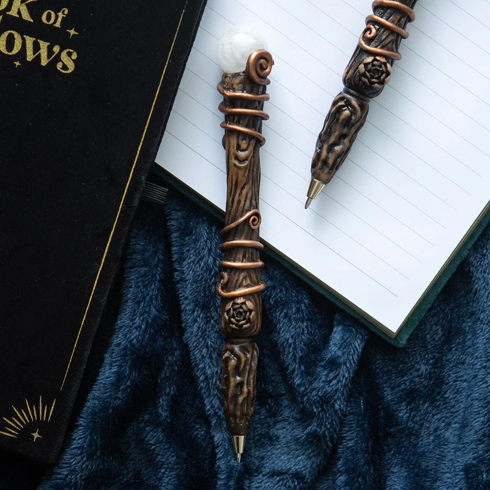 Magic wand style aura quartz crystal pen with clear quartz tip and decorative moon and star gift box background