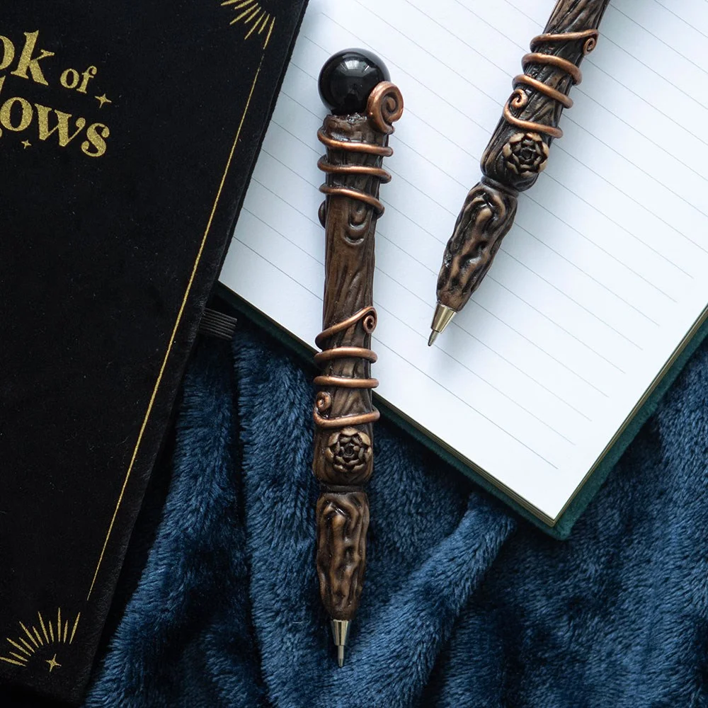 Black obsidian wand pen with crystal tip and black handle, displayed on a white background with gift box nearby