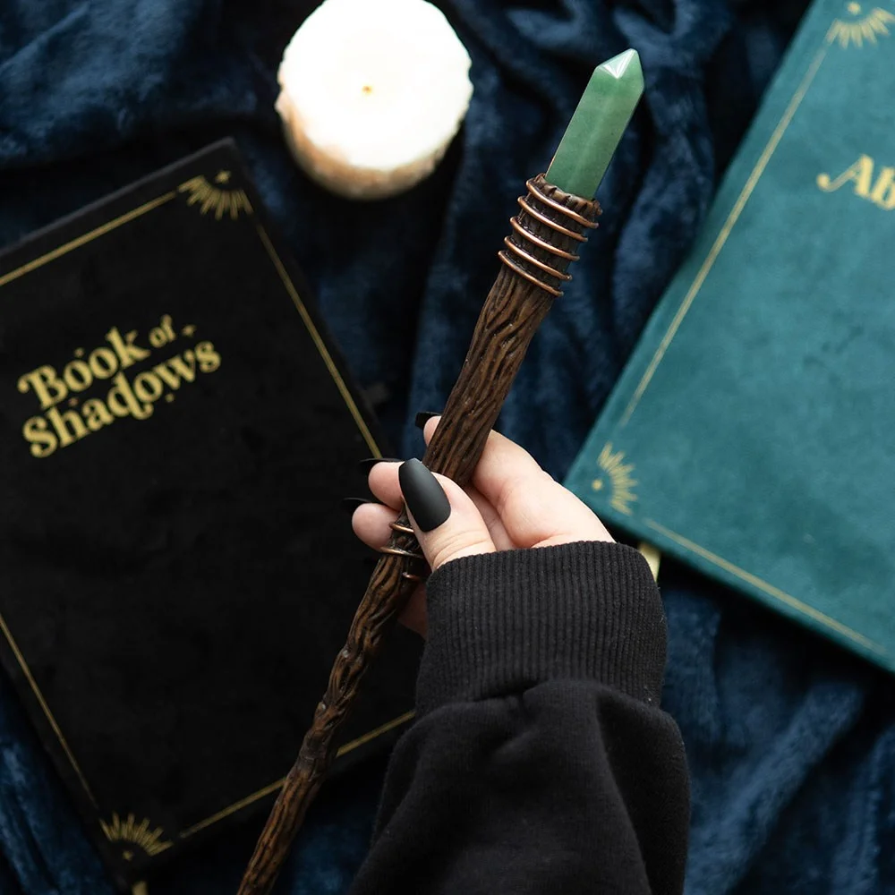 Slender green aventurine wand with a pointed crystal tip on a white background for abundance and success rituals