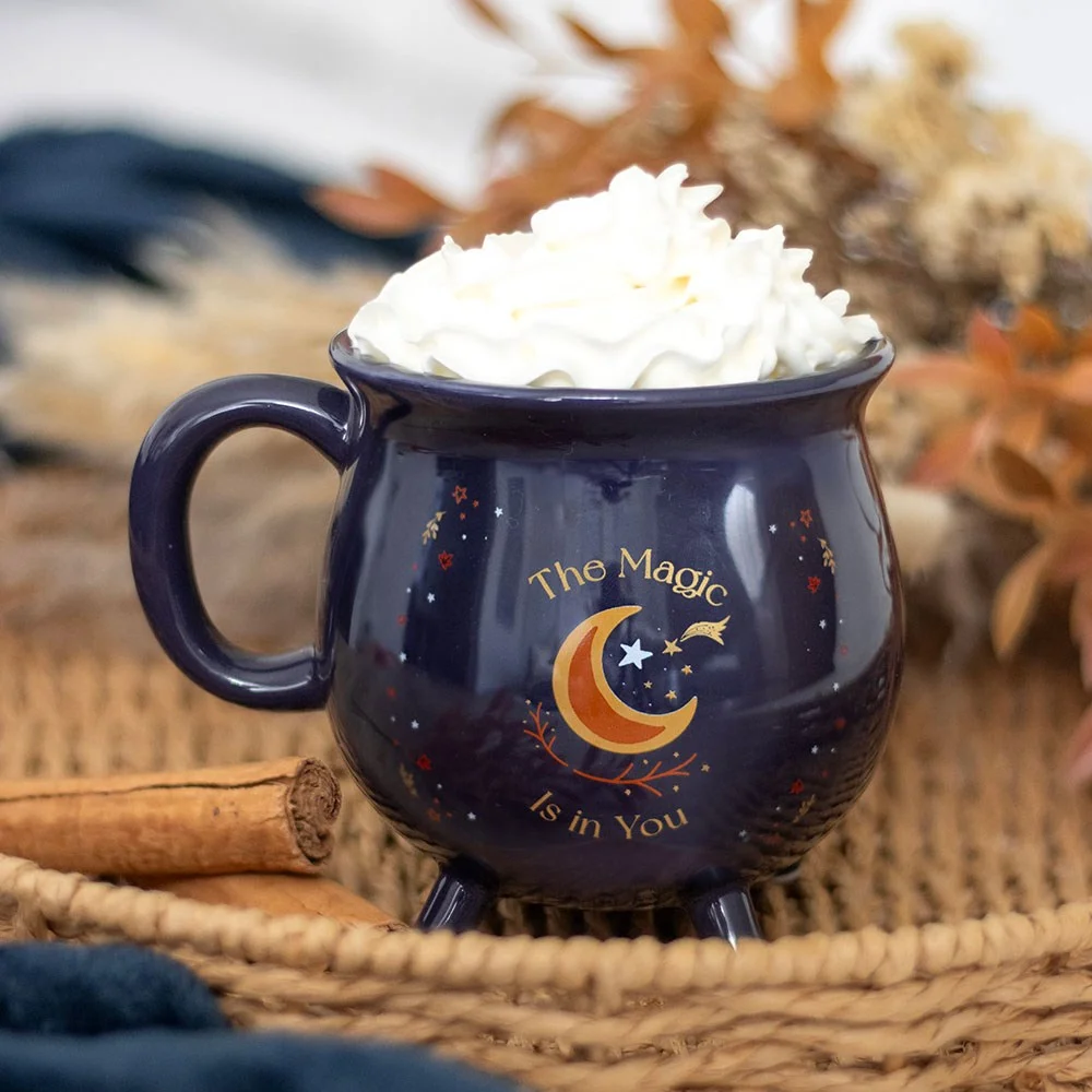 Midnight-blue cauldron mug with golden stars and crescent moon, shaped like a magical cauldron for tea or coffee