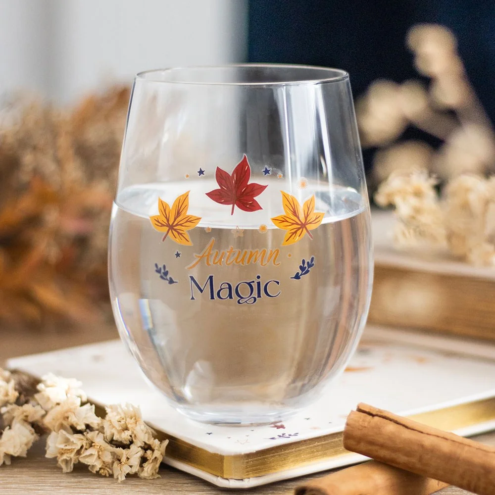 Clear autumn stemless glass with golden stars, leaves, and "Autumn Magic" text, 500ml capacity, handwash only.