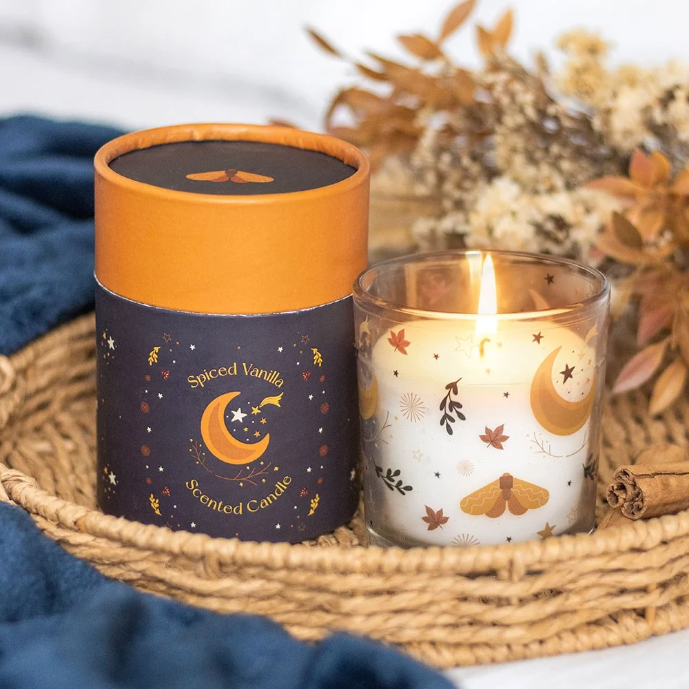 Spiced vanilla candle in glass jar with autumnal moon and leaf design, warm seasonal decor accessory