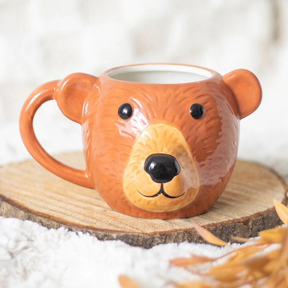 Ceramic bear shaped mug with a smiling bear face, ideal for tea, coffee, or hot chocolate, handwash only