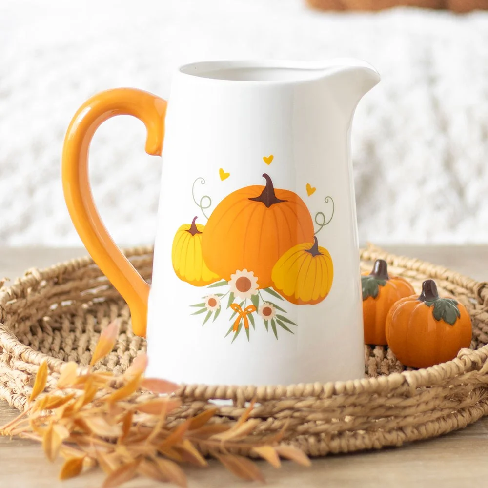 Ceramic autumn flower jug with pumpkin design and vibrant orange handle on white background