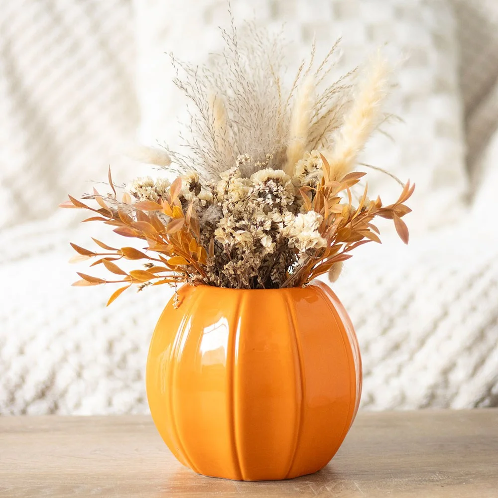 Orange pumpkin vase made of ceramic with ridged texture, shaped like a pumpkin, ideal for autumn decor or flowers