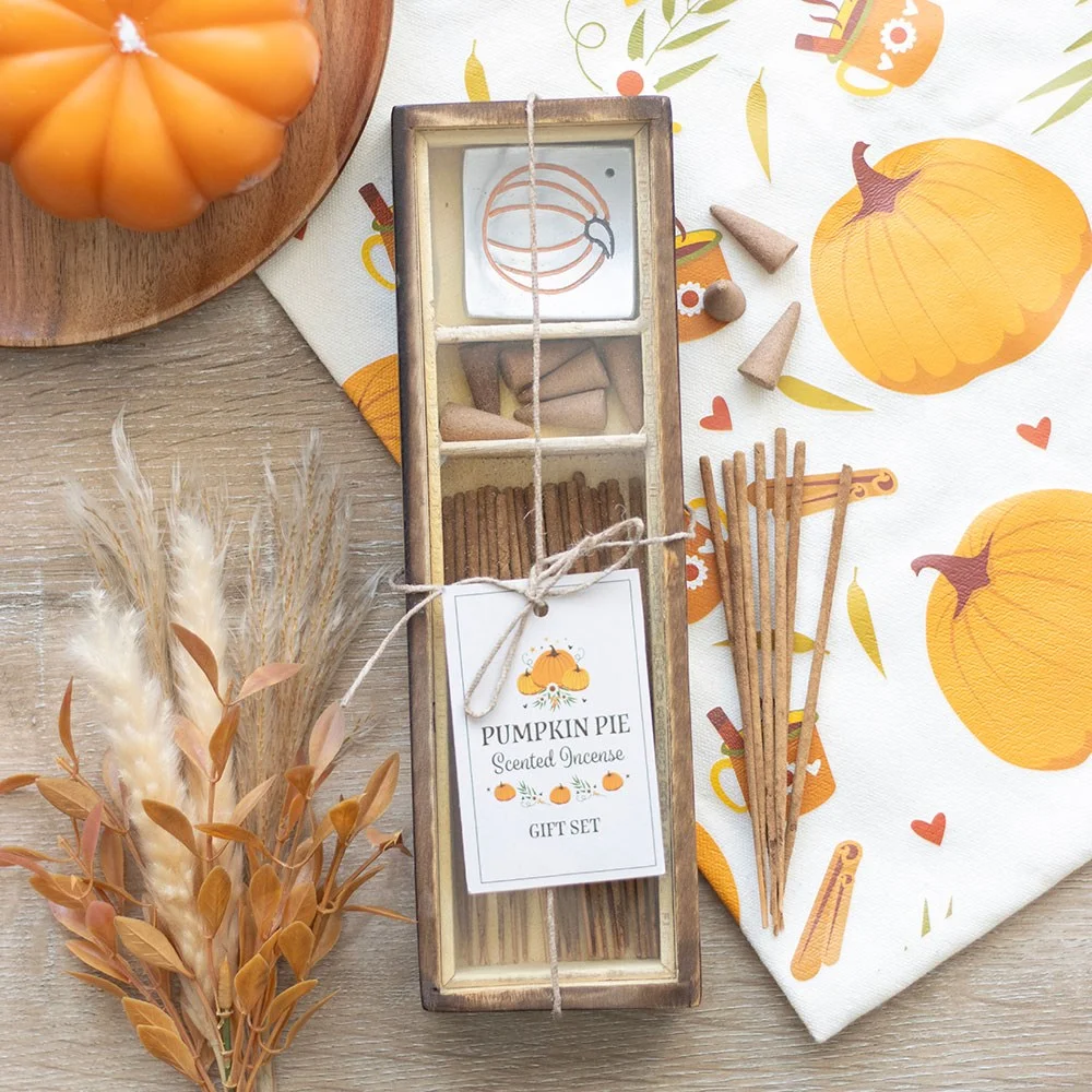 Pumpkin pie incense set with scented sticks, cones, and a pumpkin-shaped holder on a wooden surface