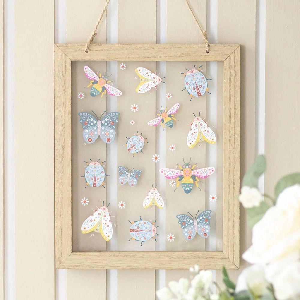 Glass wall hanging featuring a floral and bug print design with vibrant colors on clear glass panel