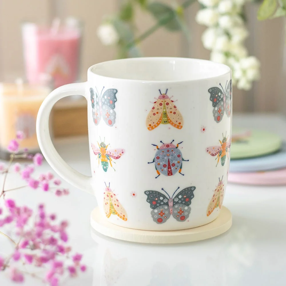 White ceramic floral bug print mug with colorful flowers and insects, 350ml capacity, on plain background