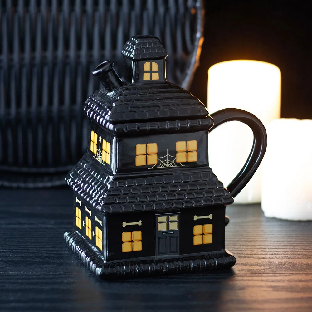 Black ceramic haunted house mug with intricate spooky design, 480ml capacity, ideal for Halloween drinks