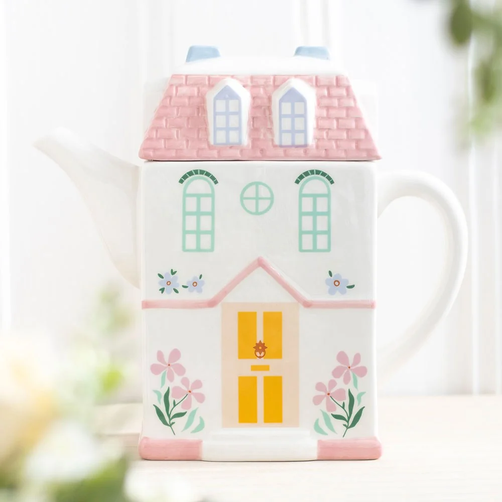 Pastel ceramic teapot shaped like a detailed storybook house with soft colors and 1300ml capacity on white background