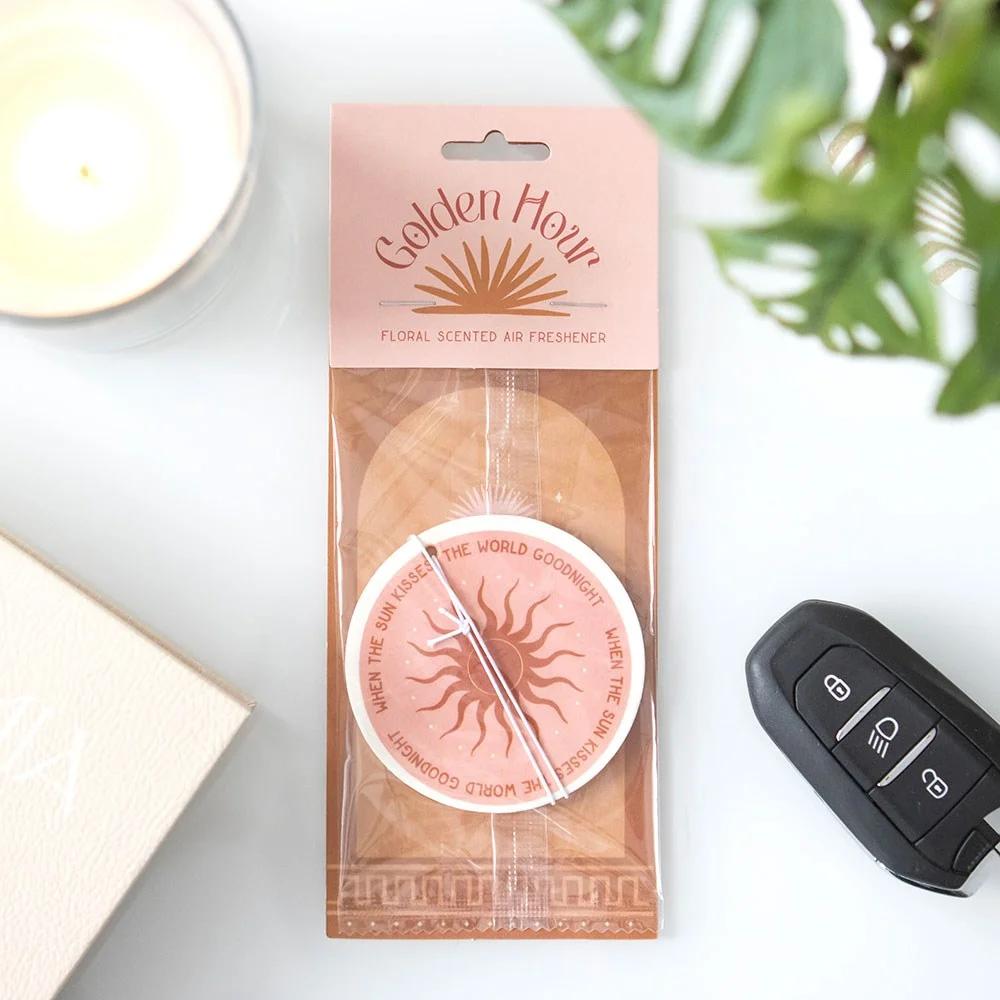 Golden Hour Sun floral scented air freshener with sun design and phrase "When the sun kissed the world goodnight