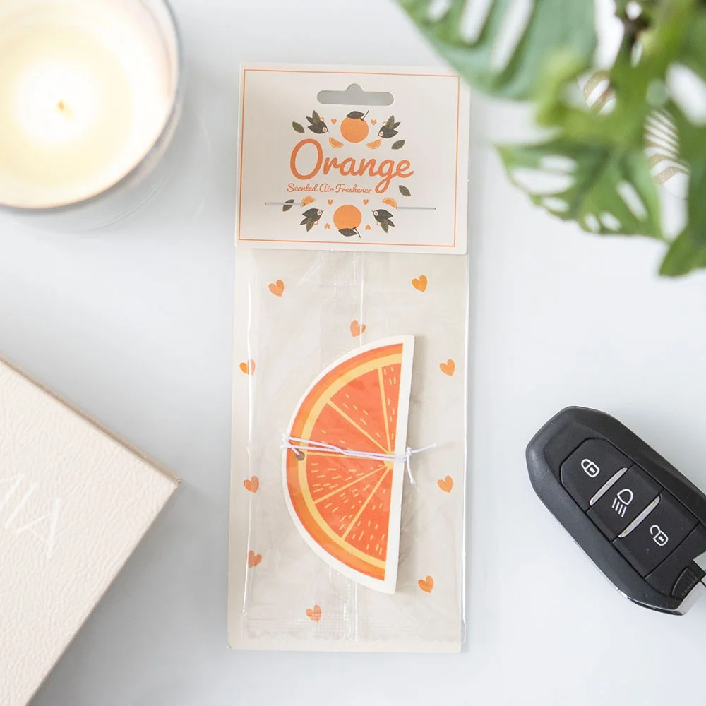Orange-shaped air freshener hanging, bright orange color with green leaf, labeled orange air freshener for car use