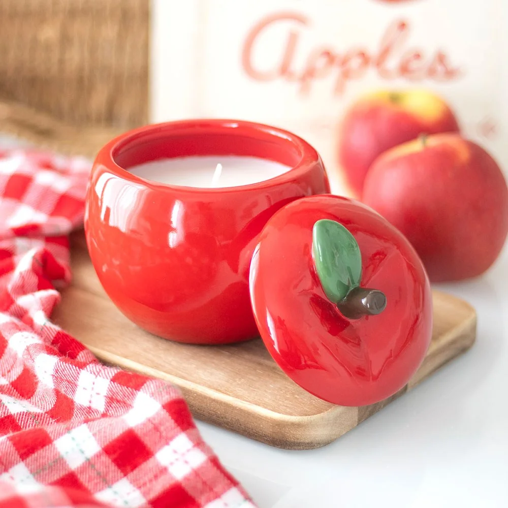 Red apple shaped candle jar with green leaf detail, designed as a scented candle for home decor and 16-hour burn time