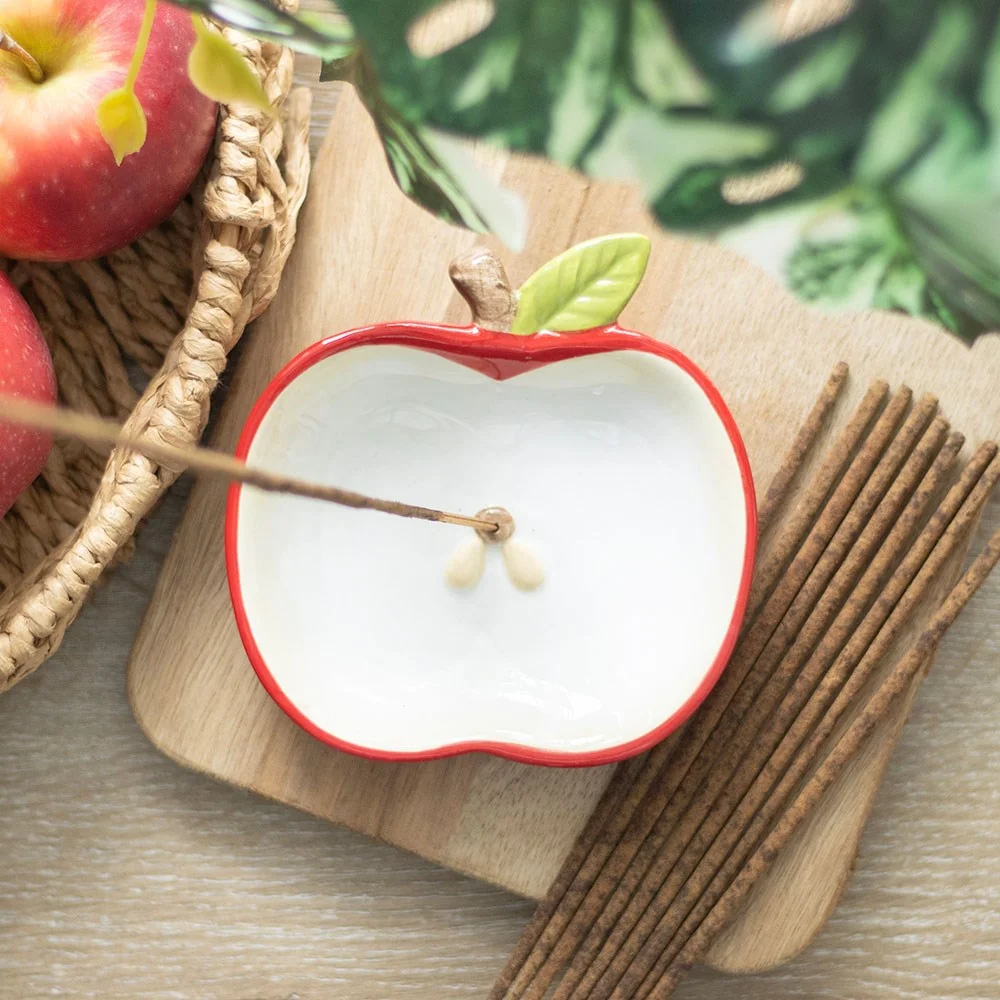 Red apple-shaped ceramic incense holder with a smooth finish, designed for home décor and relaxation.