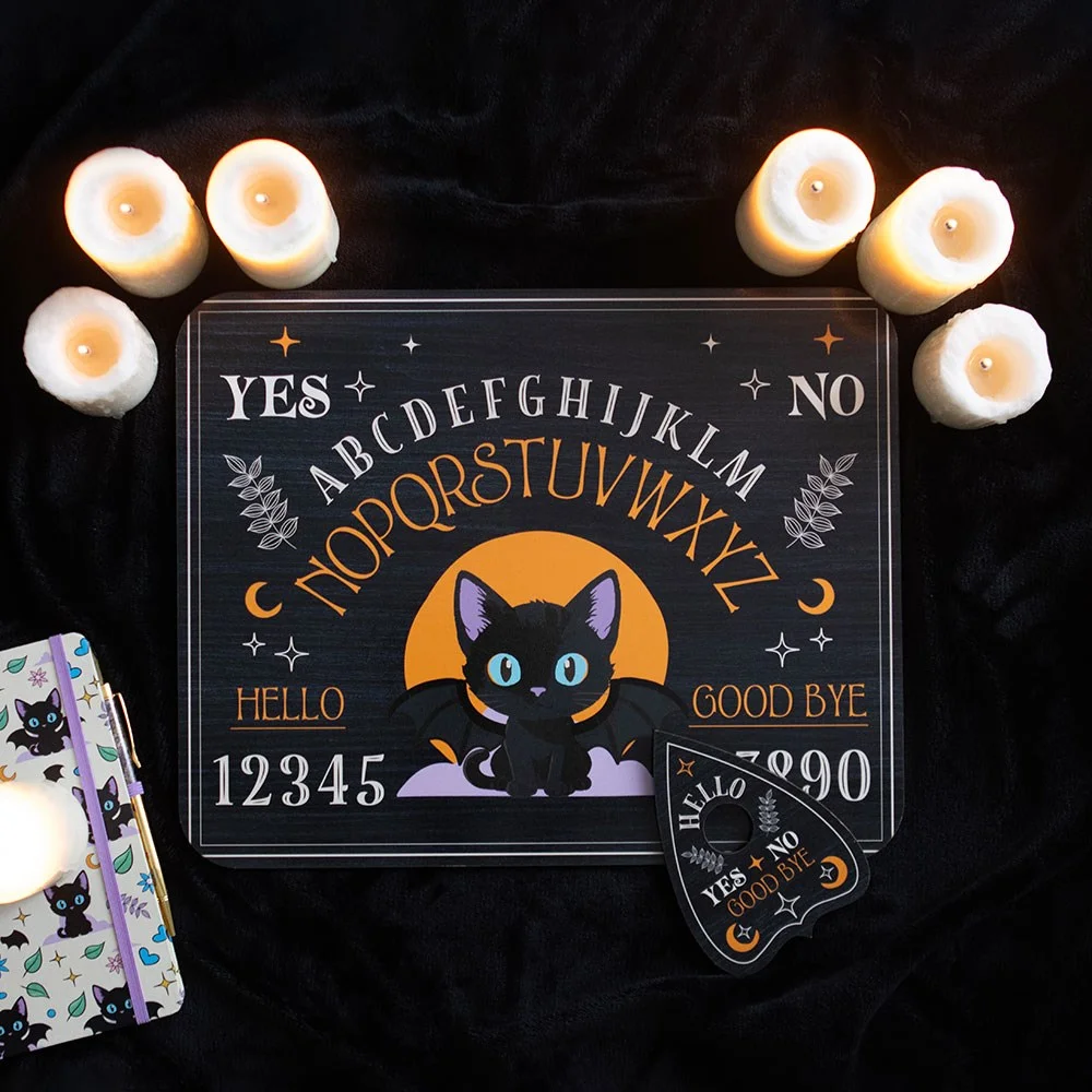 Bat cat talking board featuring a black cat, celestial symbols, and a matching planchette on a wooden surface