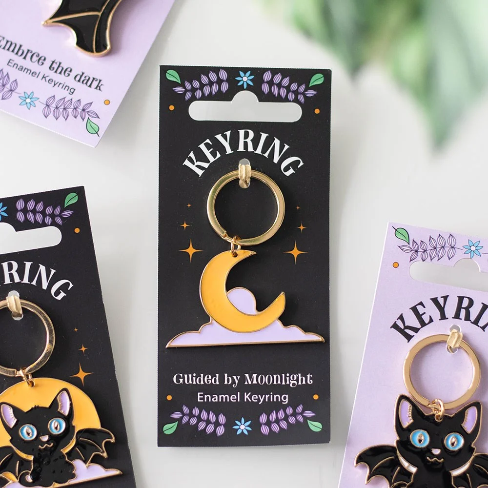 Yellow and lavender moon and stars enamel keyring on matching backing card with celestial design and night theme