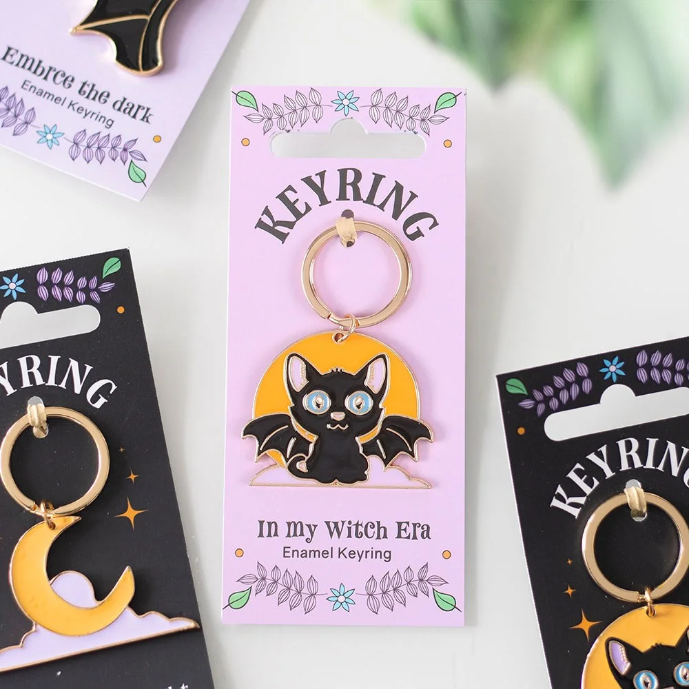 Enamel keyring with bat-winged black cat on crescent moon, perfect cat moon keyring for mystical style.