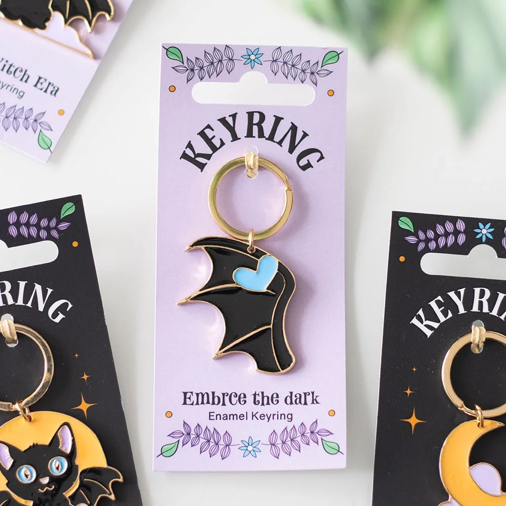 Dark enamel keyring with black bat wing design on a matching backing card for gifting