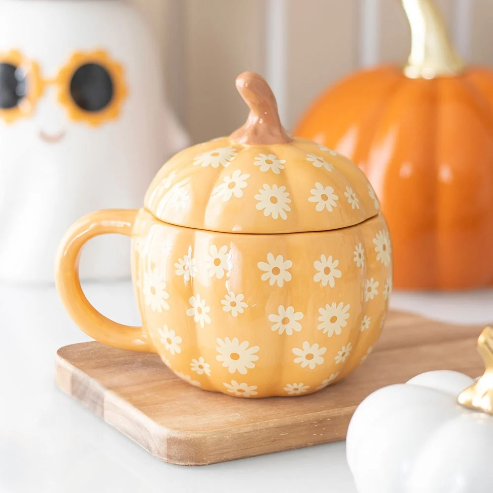 Orange ceramic pumpkin mug with lid featuring groovy floral design, 500ml capacity, autumn-themed drinkware
