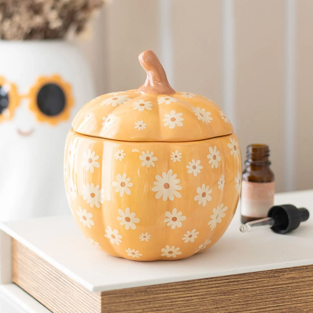 Orange pumpkin oil burner with groovy floral pattern, designed for autumn and Halloween decor with fragrance oil use