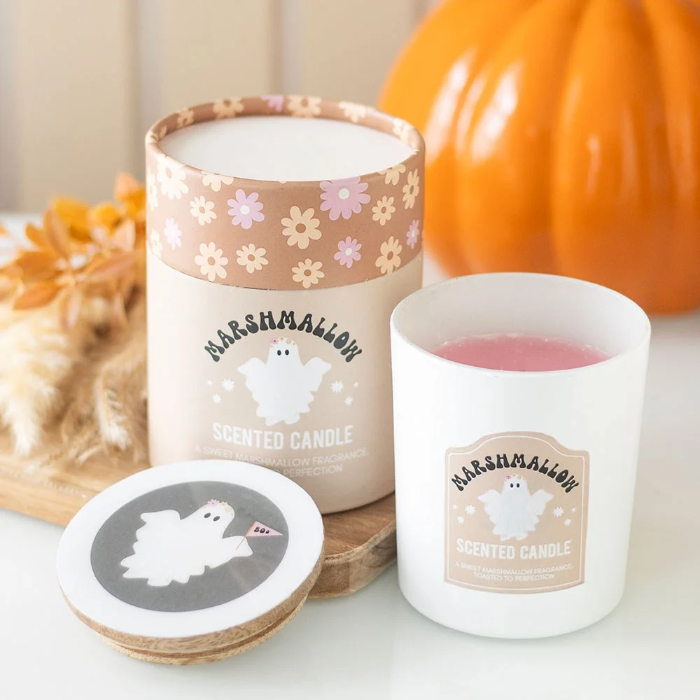 Ghost-shaped toasted marshmallow candle in glass holder with wooden lid featuring ghost and flower designs