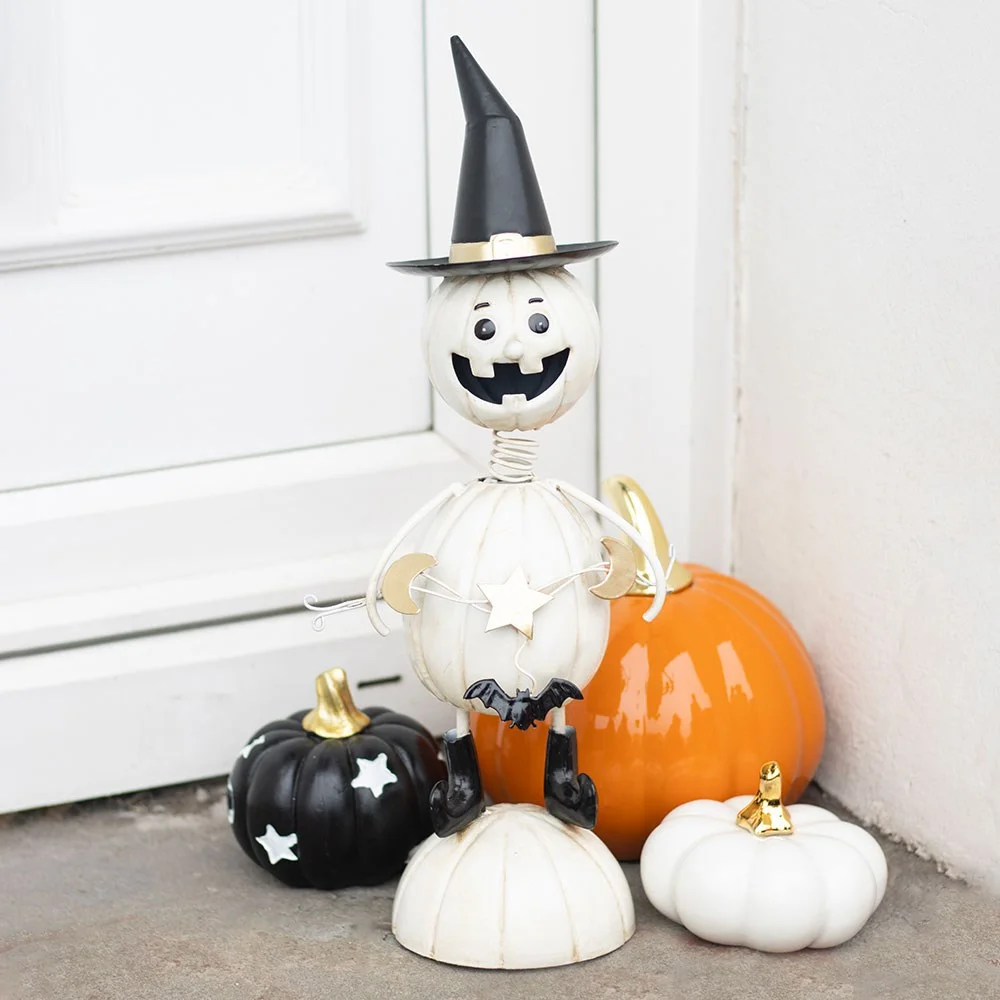 White metal pumpkin ornament shaped like a man wearing a tall witch hat with wire arms for Halloween decor