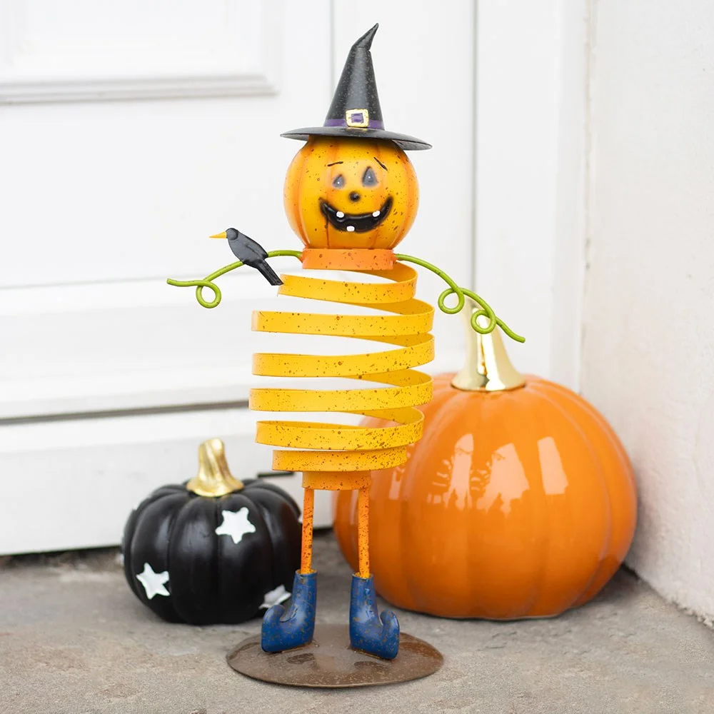 Orange metal pumpkin ornament with spring body, wearing a witch's hat and wire details, ideal for Halloween decor