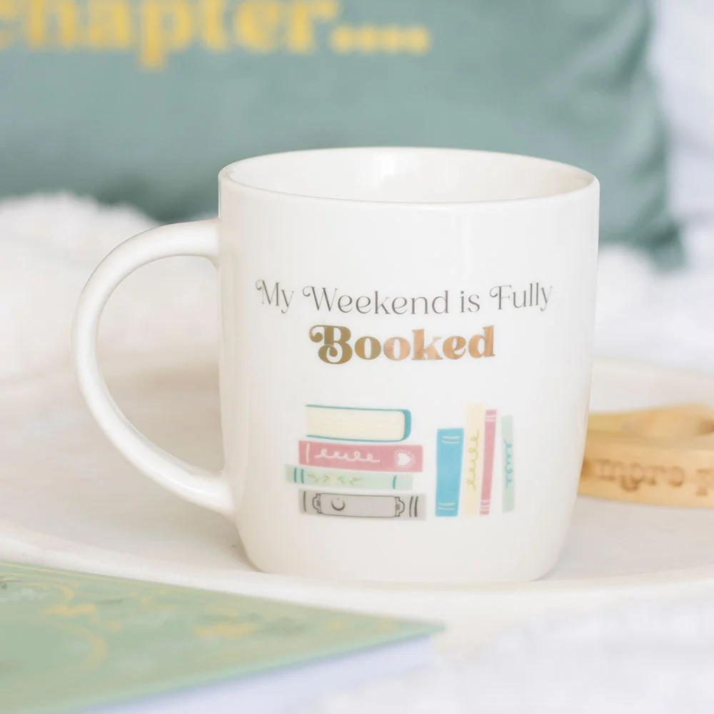 Ceramic mug with printed 'My Weekend is Fully Booked' on a white background, a book lover mug for slow weekends.