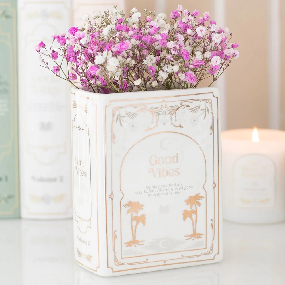 White ceramic book shaped vase with spine lines, open cover, suitable for fresh or dried flowers, 600ml capacity.