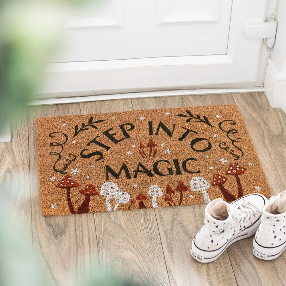 Cheerful step into magic doormat with cute mushroom motif and Step Into Magic lettering, perfect for a whimsical doorway.